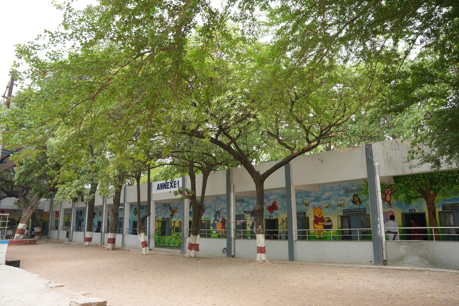 Classroom annexe seen from the grounds, its walls covered in colourful murals