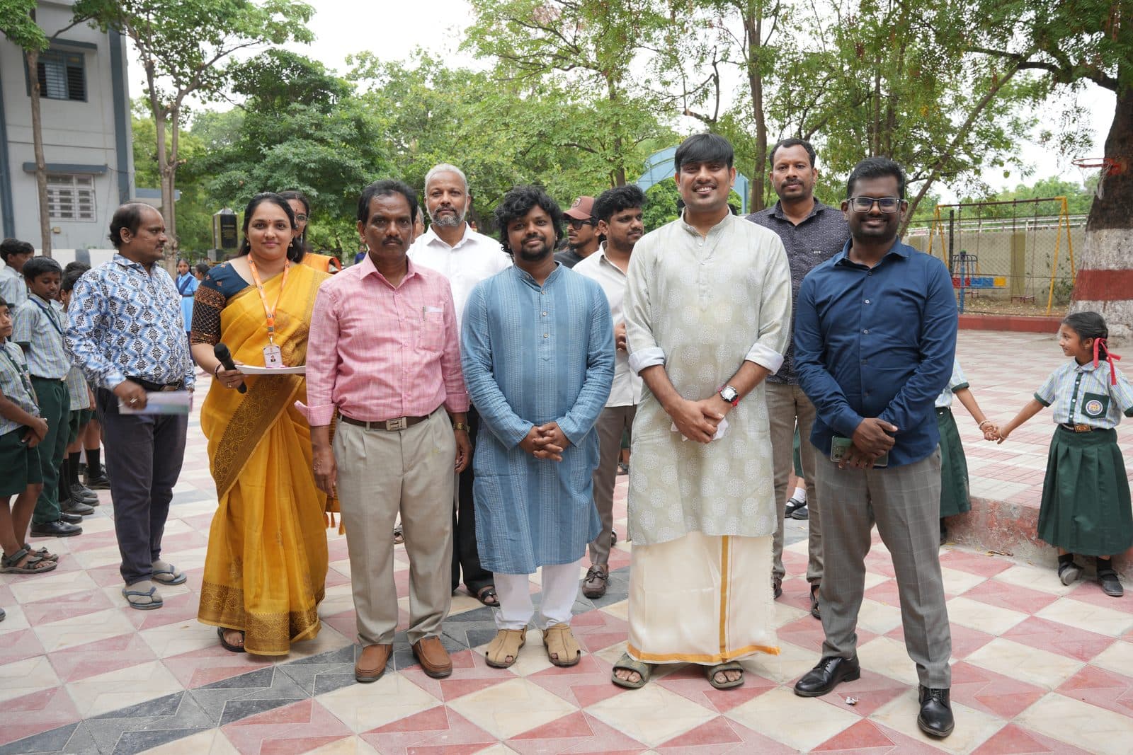 Guests and staff standing together for a group photograph in the school courtyard