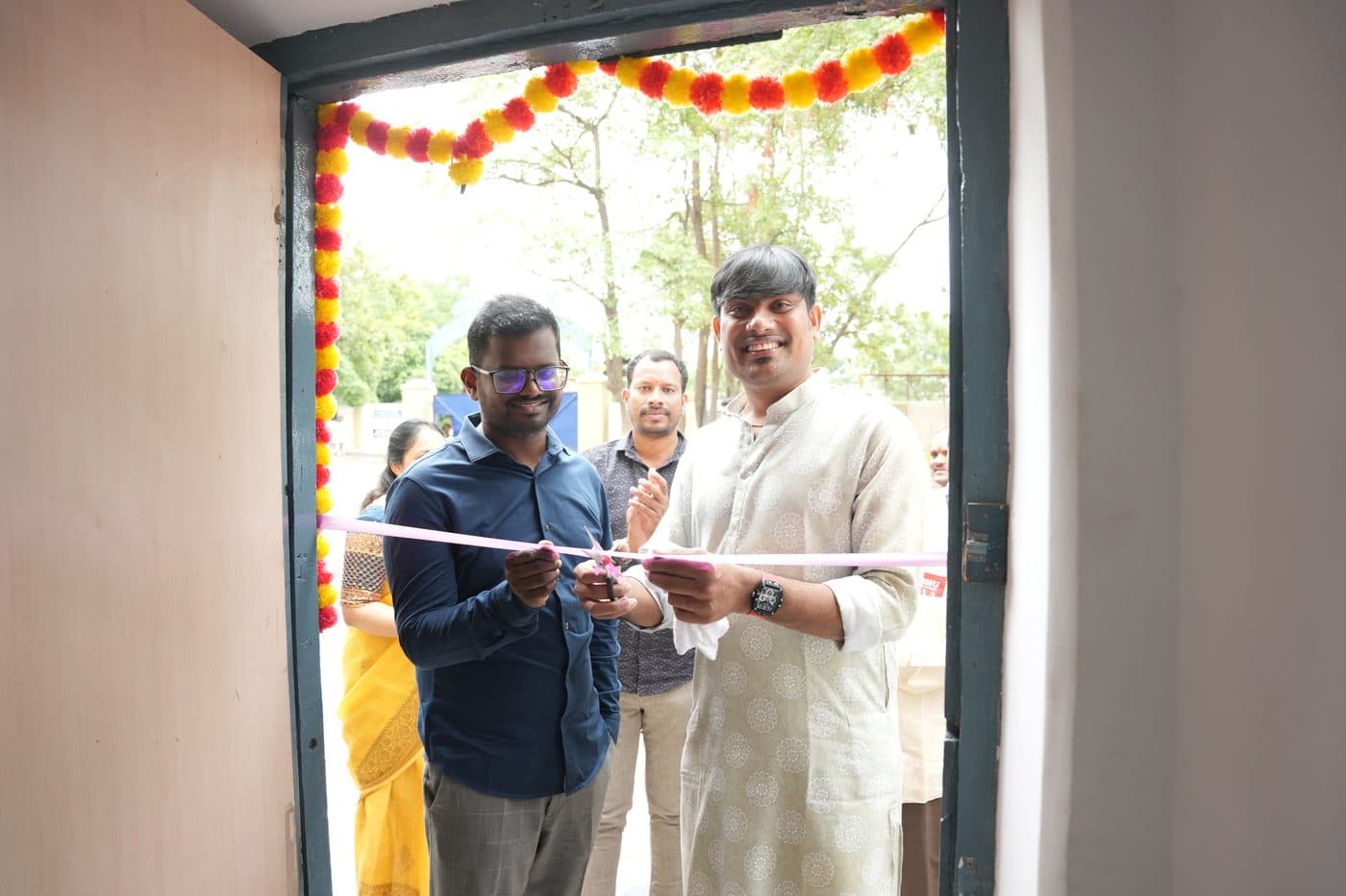 Guests cutting the ribbon at the entrance to a newly opened room