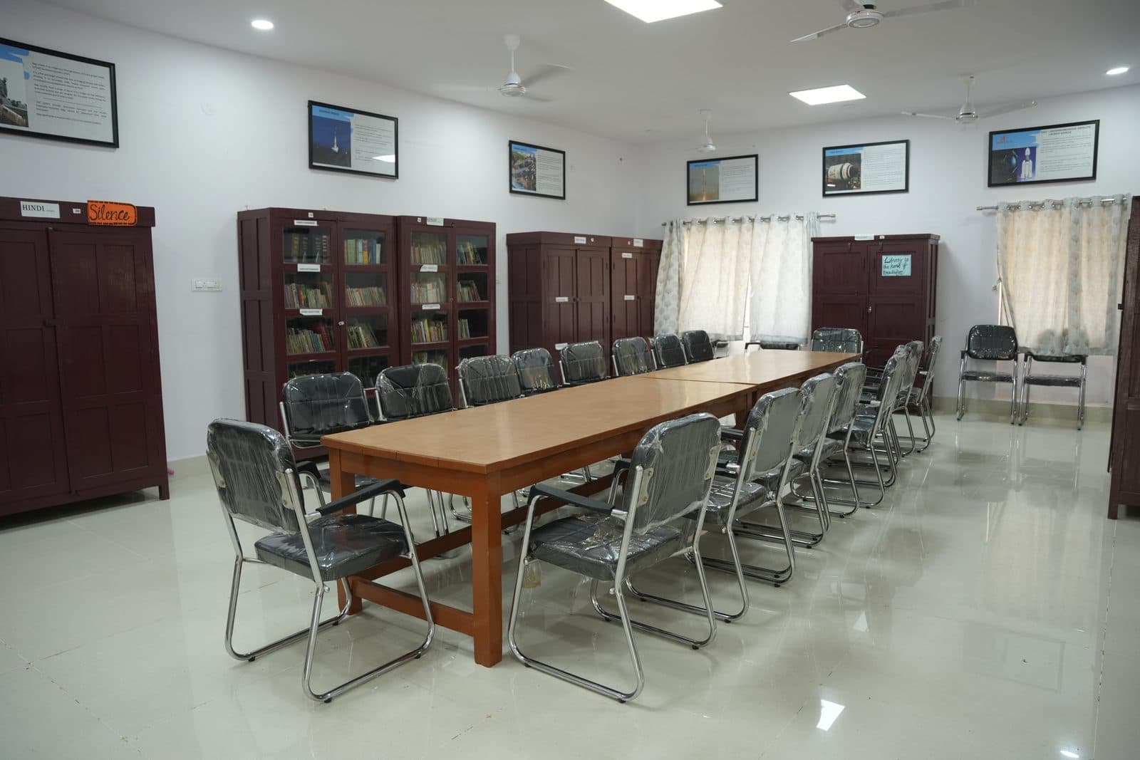 The school library with its long central reading table, chairs and glass-fronted bookcases