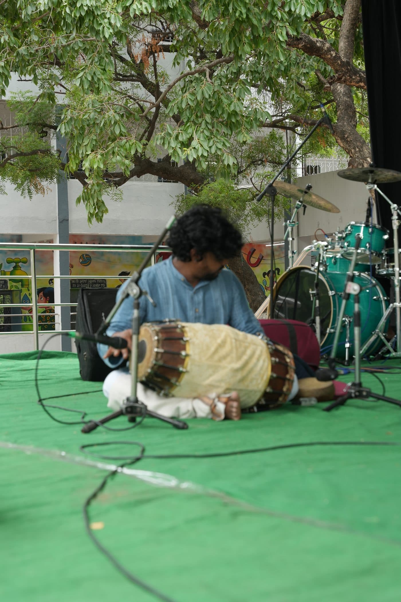 A percussionist playing the mridangam during the cultural programme