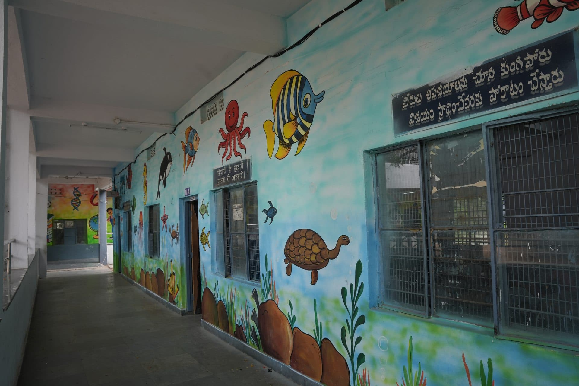 A classroom corridor painted end to end with an underwater mural of fish, turtles and coral