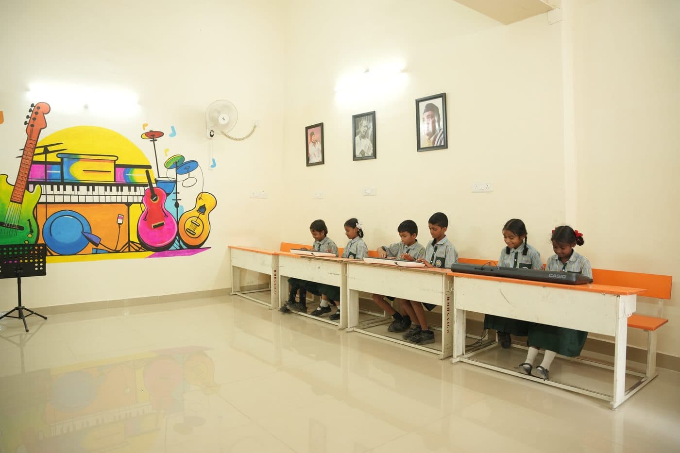 Students seated at desks in the music classroom with a keyboard on the bench in front of them