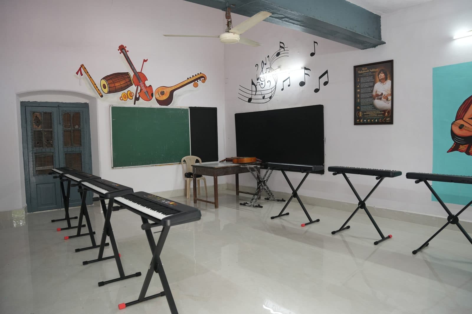 The Tanmayam music room, with electronic keyboards on stands and painted instrument motifs on the walls