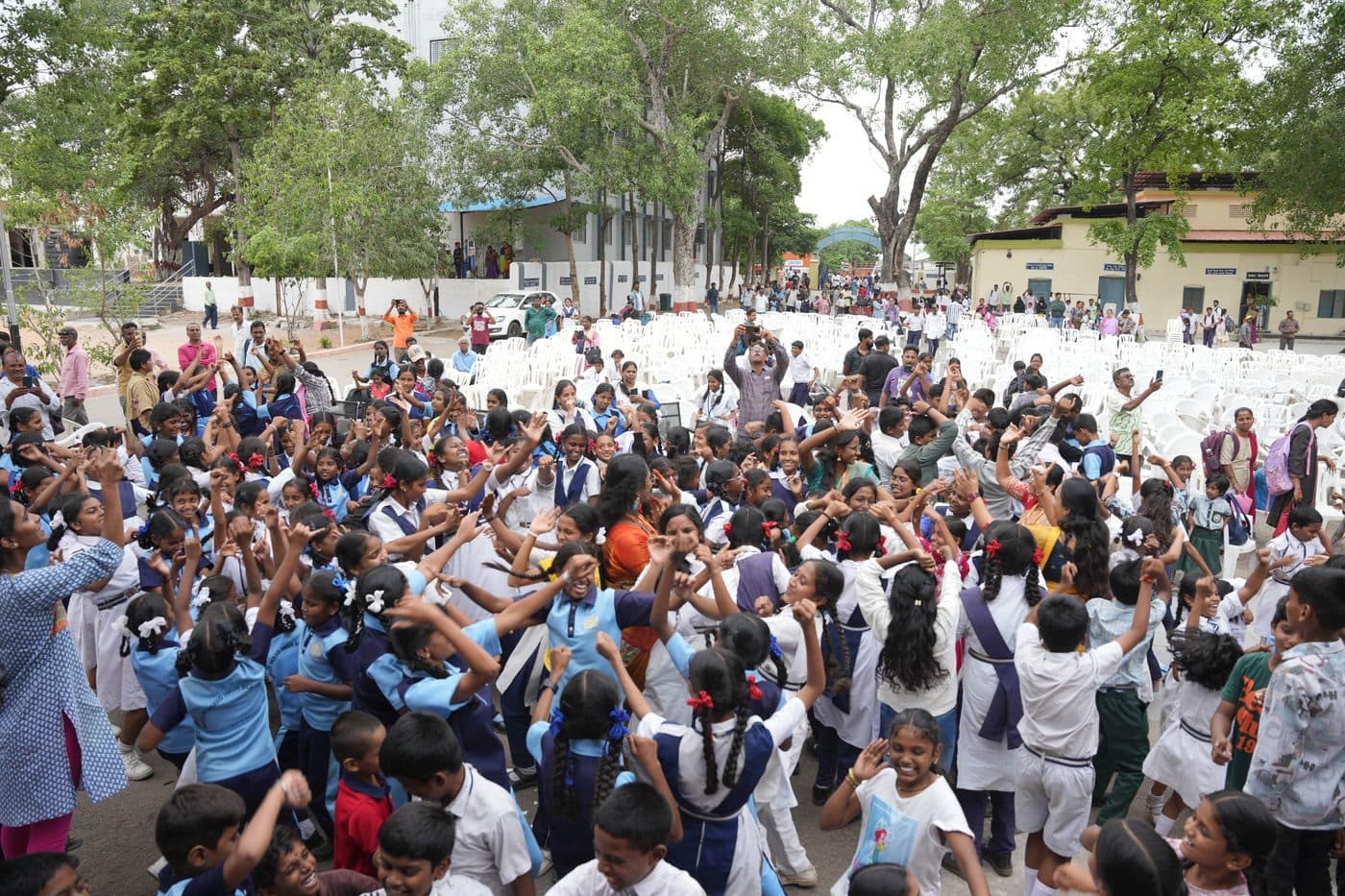 A large group of students dancing in the open ground during a school event