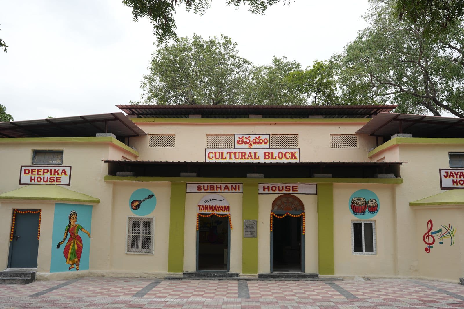 Front elevation of the Tanmayam cultural block with painted dancer and instrument motifs