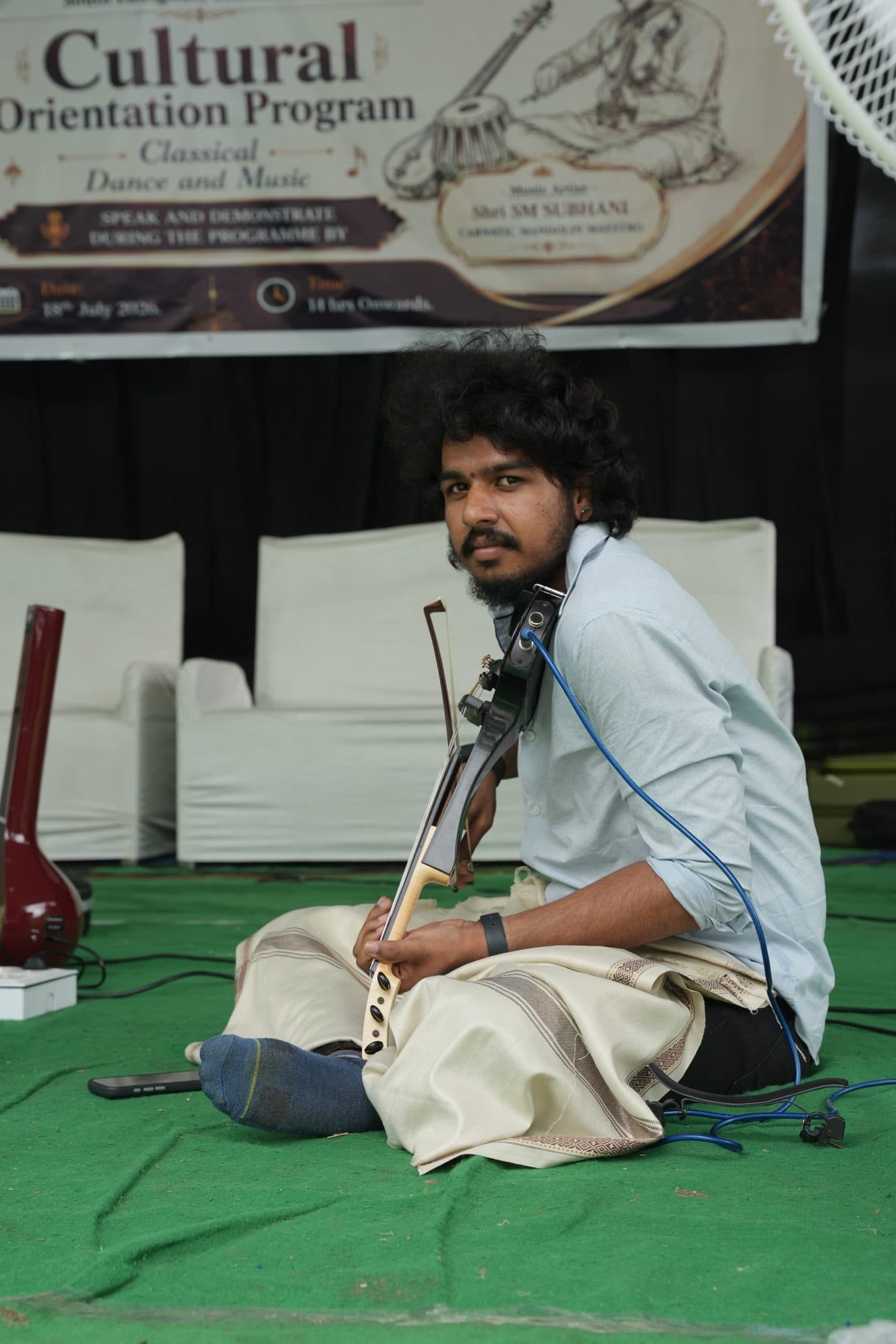 A violinist performing in the Carnatic seated position during the cultural programme